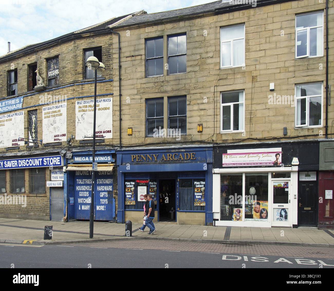Bradford, West yorkshire, vereinigtes Königreich, 19. juni 2019: Zwei Menschen laufen an einem verlassenen Geschäft und einer Spielhalle auf dem Oastler Square in bradford West y vorbei Stockfoto