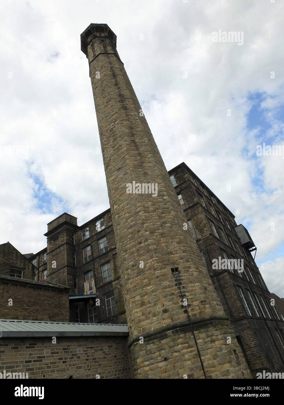 Altes industrielles Steinmühle-Gebäude mit hohem Kamin in huddersfield im Westen yorkshires Stockfoto