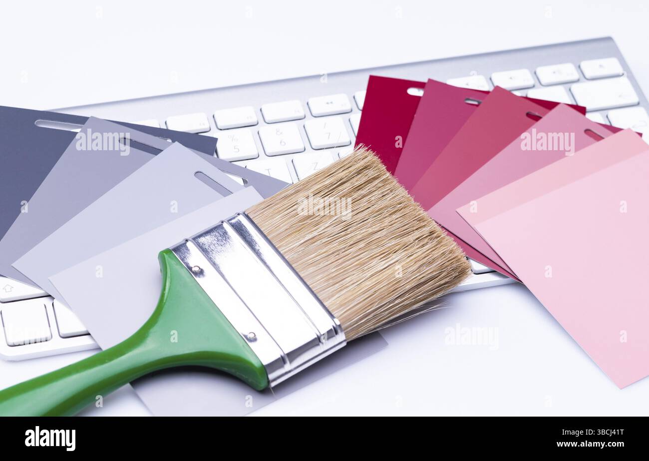 Das Foto zeigt einen flachen Pinsel mit verschiedenen Farbmustern auf einer Tastatur Stockfoto