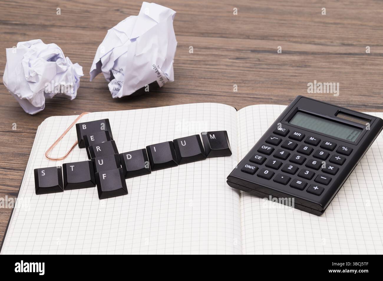 Notiz-Blog mit Rechner, Pad und Buchstaben auf einem Holztisch Stockfoto