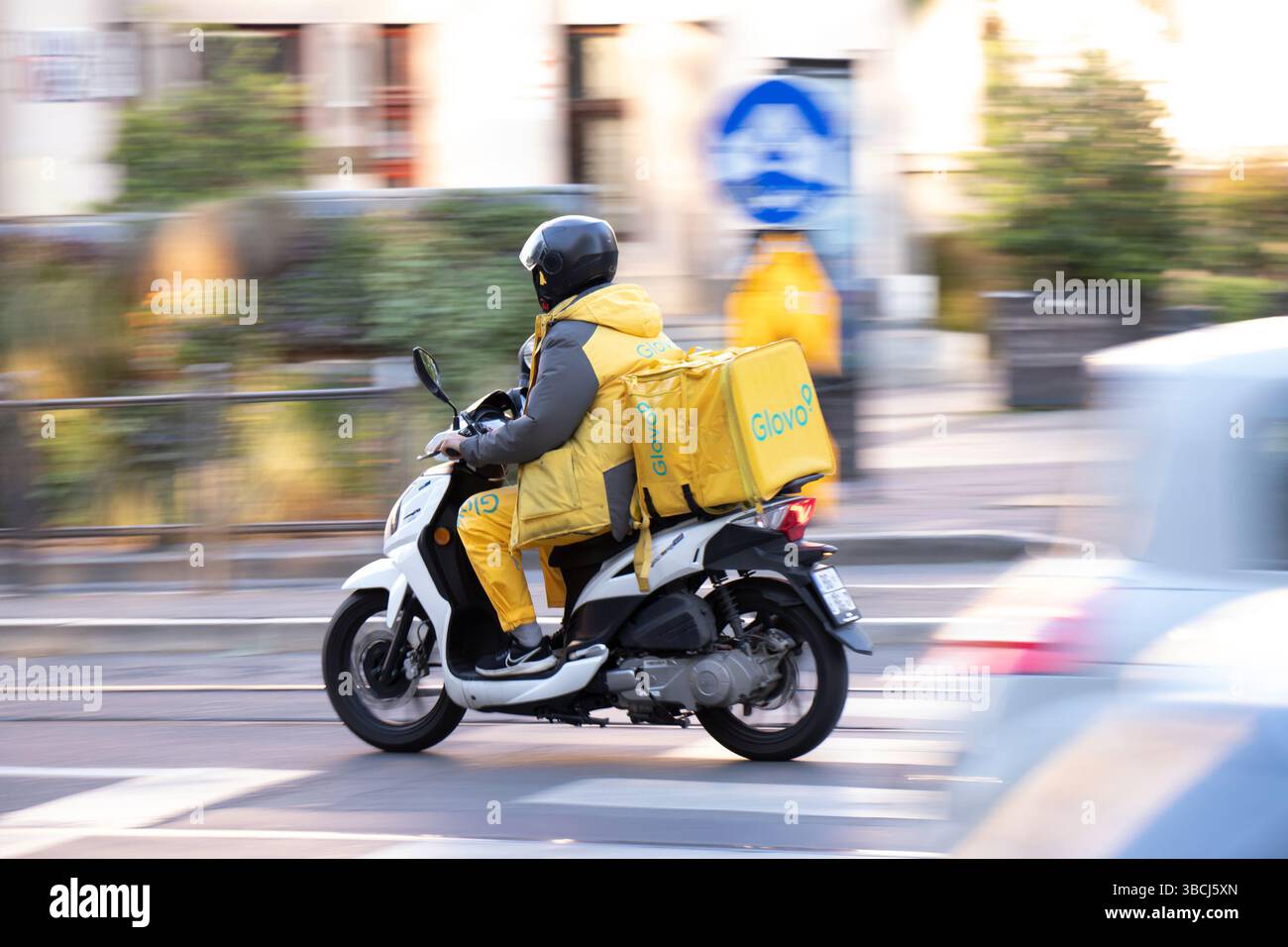 Belgrad, Serbien - 17. Mai 2025: Glovo Service-Kurier mit einer Liefertasche im Straßenverkehr Stockfoto
