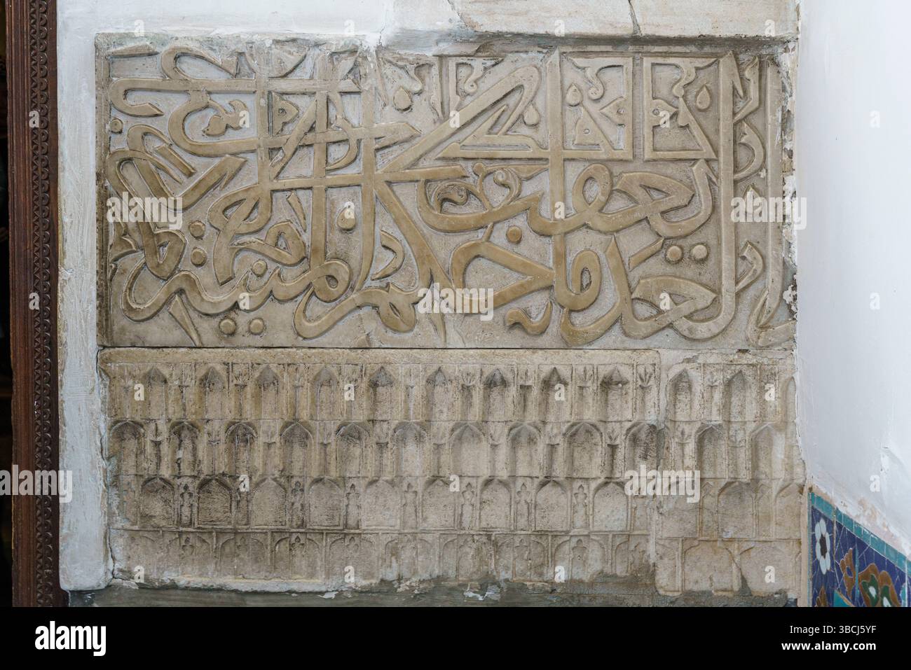 Die Marmoroberfläche im Mausoleum Gur e Amir in Samarkand, Usbekistan, ist mit zarter arabischer Kalligraphie und prächtigen geschnitzten Dekorationen versehen. Stockfoto