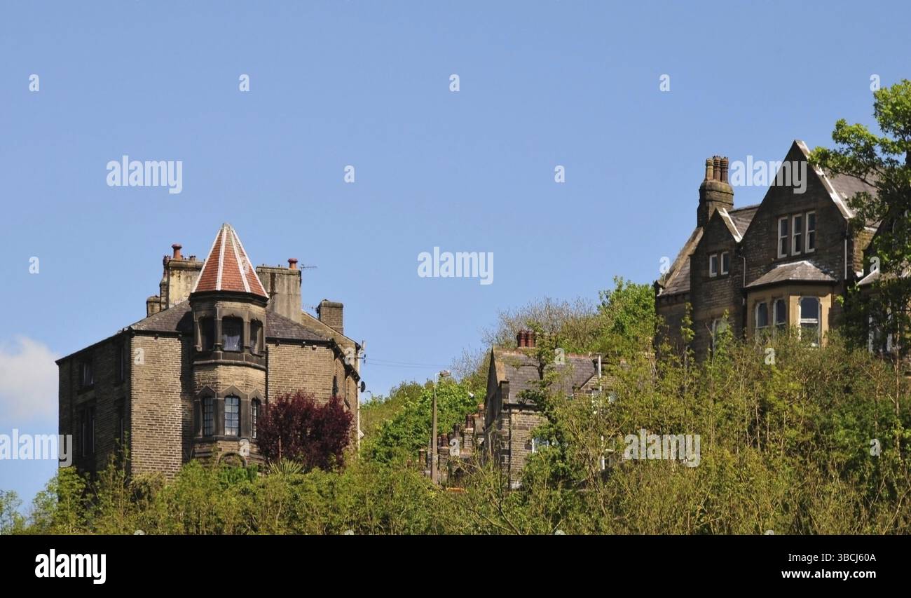 Hohe gotische Steinhäuser in der Waldlandschaft i hebden Bridge West yorkshire mit blauem Himmel Stockfoto