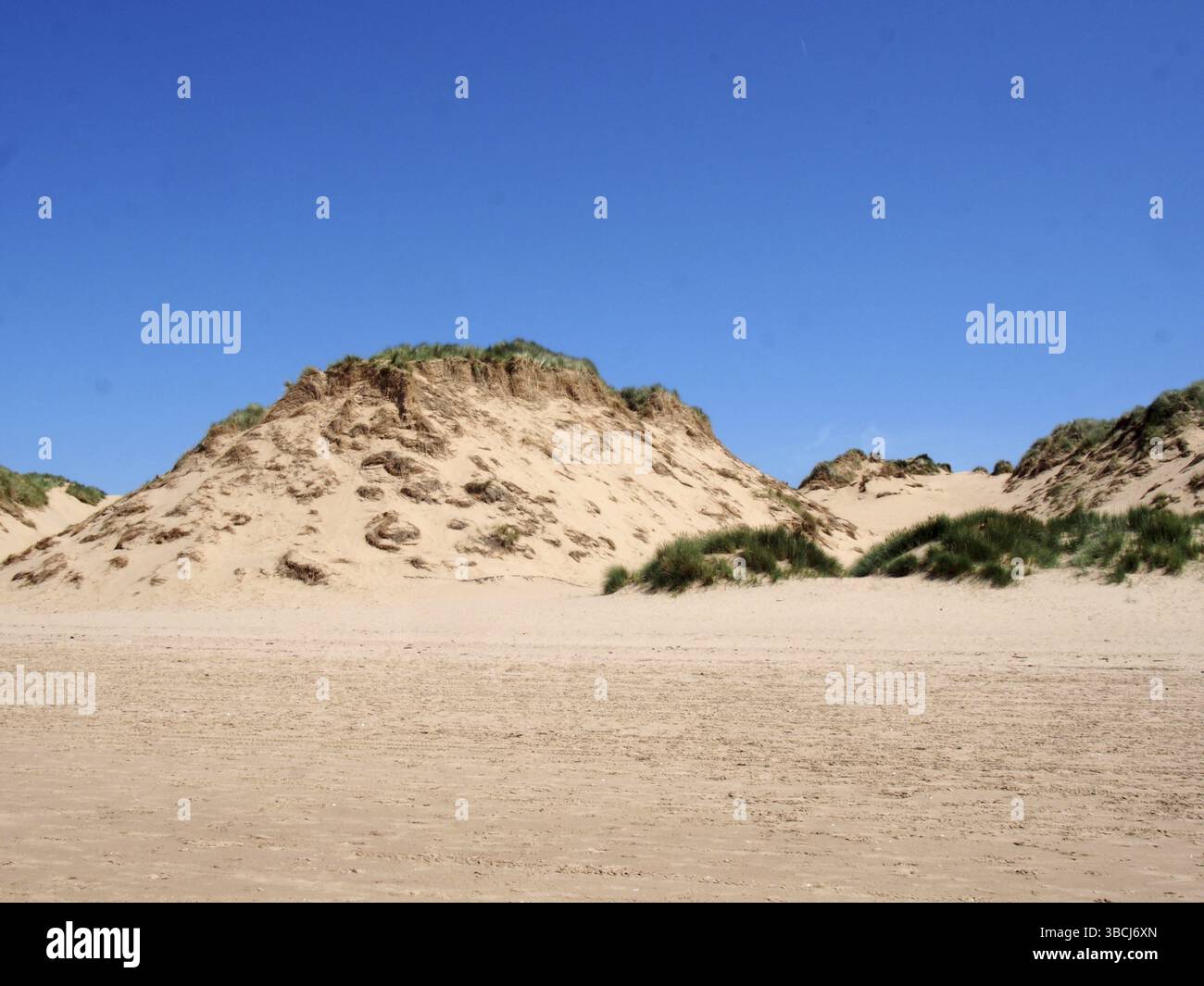 Der Strand von formby merseyside mit hohen Sanddünen, die mit rauem Gras bedeckt sind, und einem blauen sonnigen Sommerhimmel Stockfoto