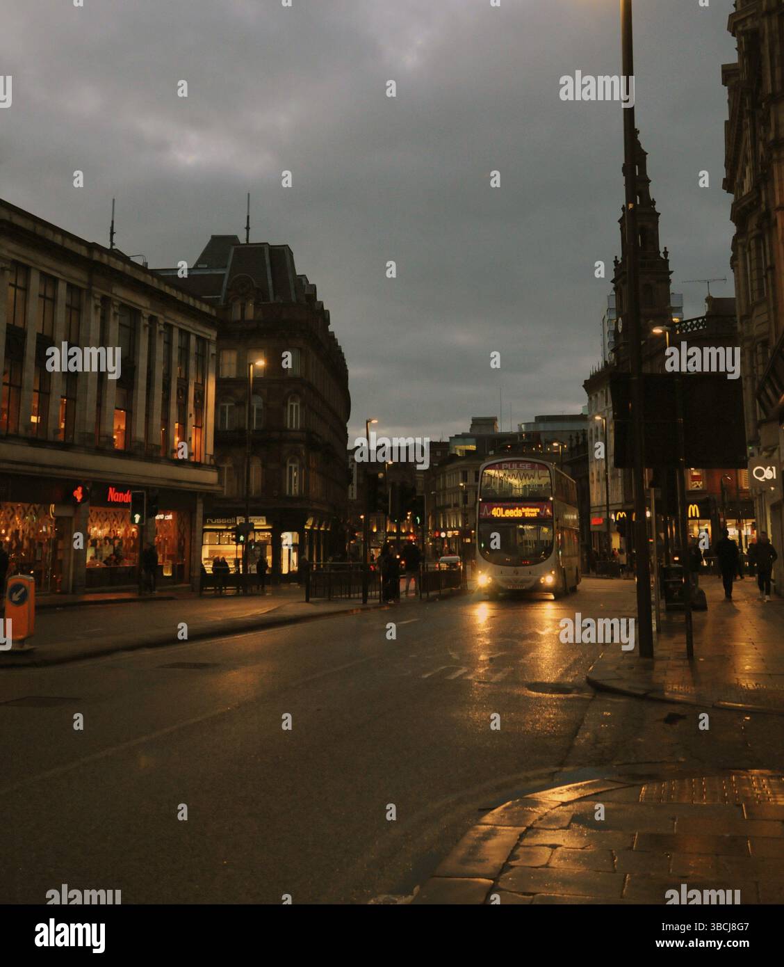 Leeds, England, 18. Januar 2018: Pendler und Busse auf der Straße in der Wildbahn im Stadtzentrum von leeds am Abend mit beleuchteten Geschäften Stockfoto