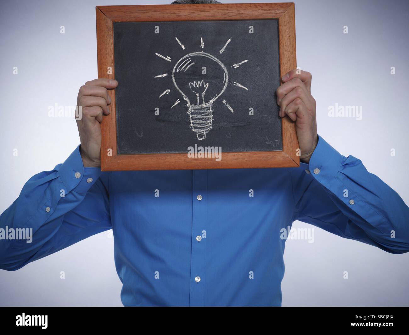 Geschäftsmann hält eine Tafel mit einem handgezeichneten Glühbirne, tolle Idee-Konzept Stockfoto