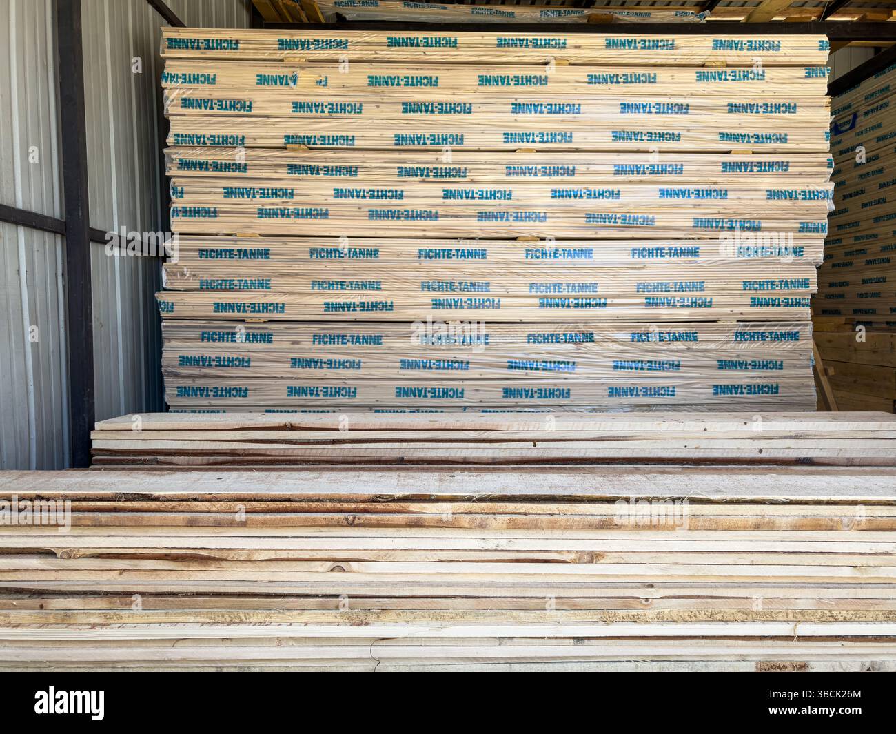 Im Lager gelagerte Holzstapel, verpackt in FICHTE-TANNE-Verpackungen. Nur redaktionelle Verwendung. Keine Personen. Stockfoto