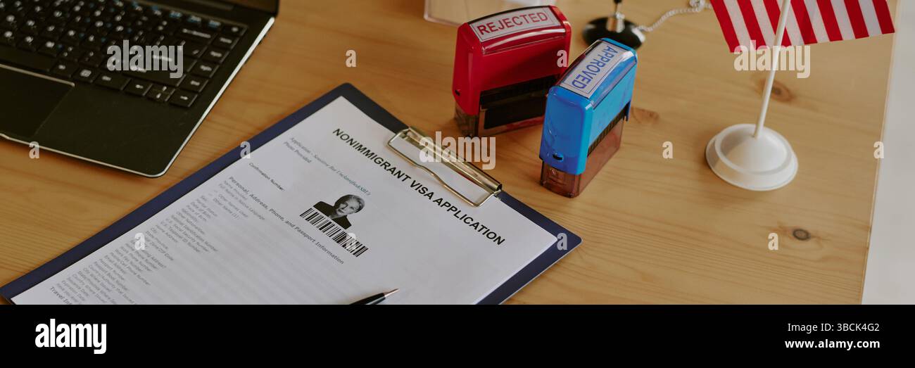 Dokumententabelle mit Antragsformular für Nichteinwanderungsvisa sowie abgelehnten und genehmigten Stempeln, Laptop und US-Flagge. Setup mit offiziellem Verfahren Stockfoto