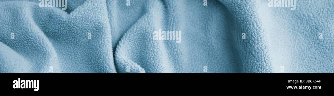 Hellblaue fließende Textiloberfläche. Sanfte Wellen in hellem Gewebe Stockfoto