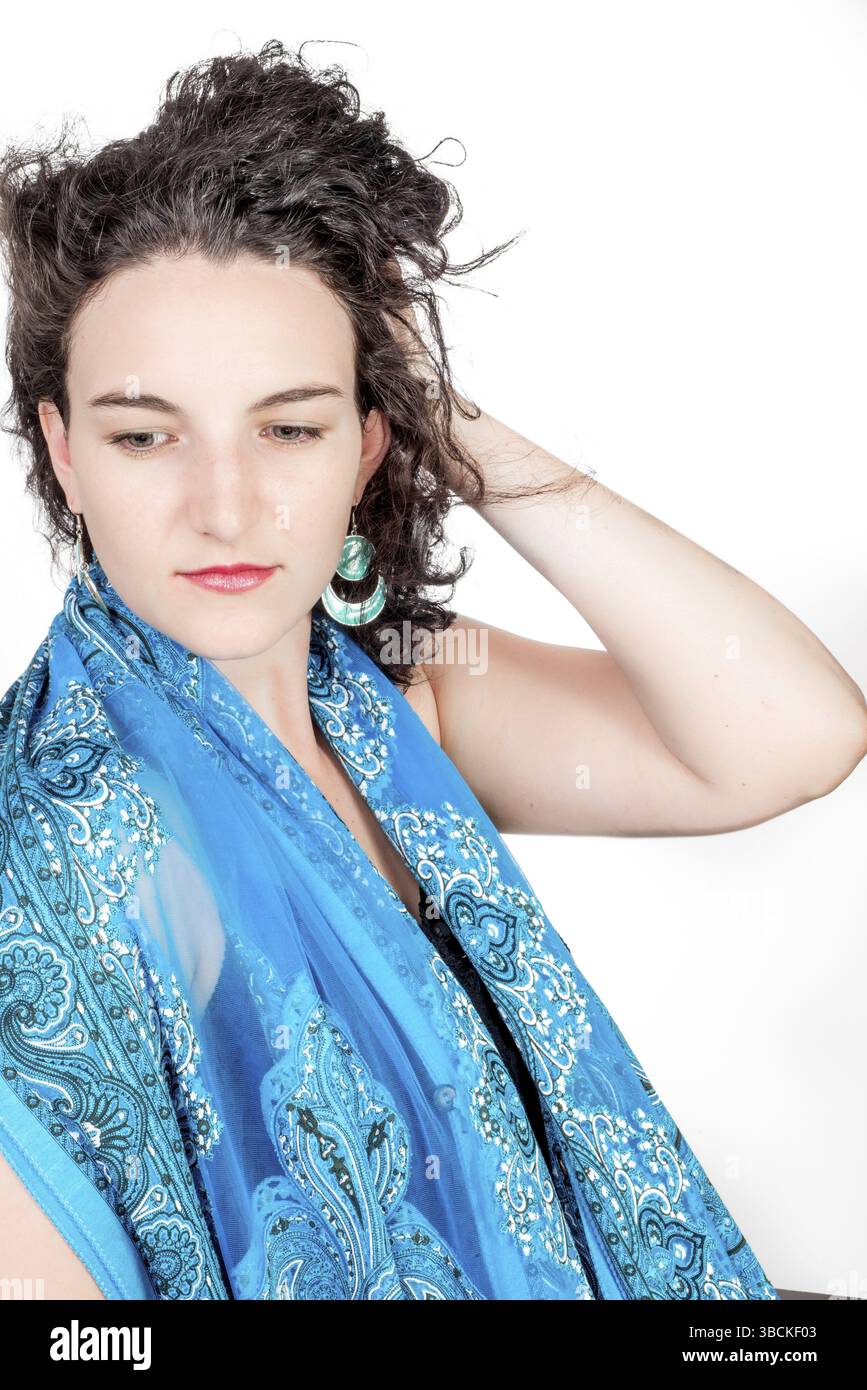 Ein junges Model, Mitte 20, trug aquafarbene Ohrringe im nahöstlichen Design und einen blauen Schal Stockfoto