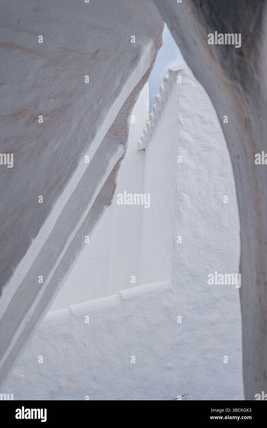 Rein weiße abstrakte architektonische Details in mediterraner Umgebung, minimalistische Formen. Weiß getünchte Wände, geschwungene Linien, glatte Textur, helles Licht Stockfoto