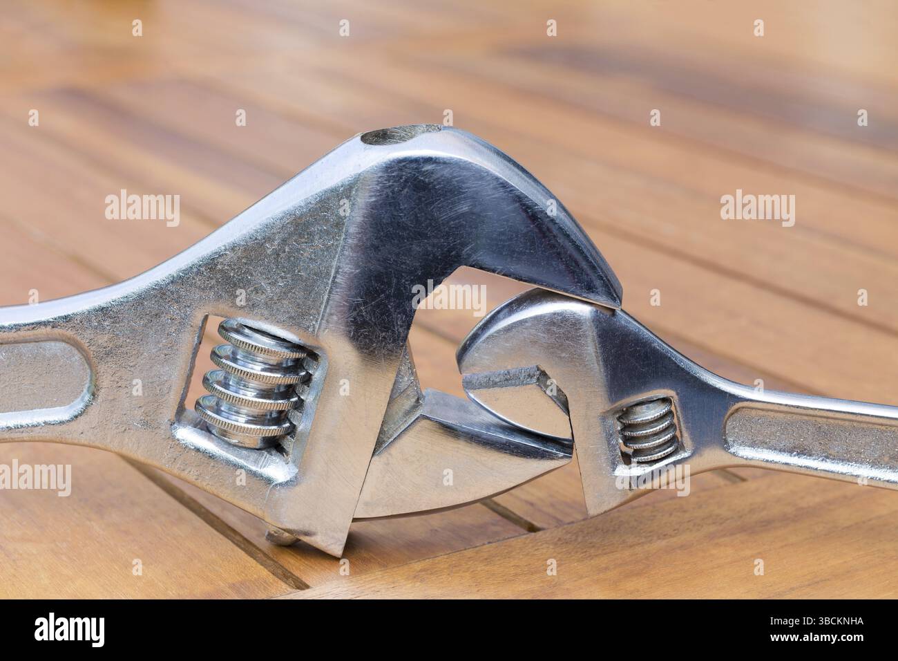 Große und wenig verstellbaren Schraubenschlüssel zusammen auf Holztisch Stockfoto