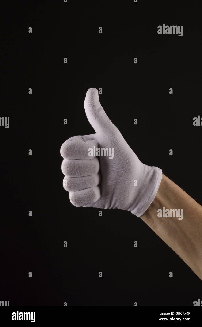 Männliche Hand mit weißen Handschuhen mit Daumen Stockfoto