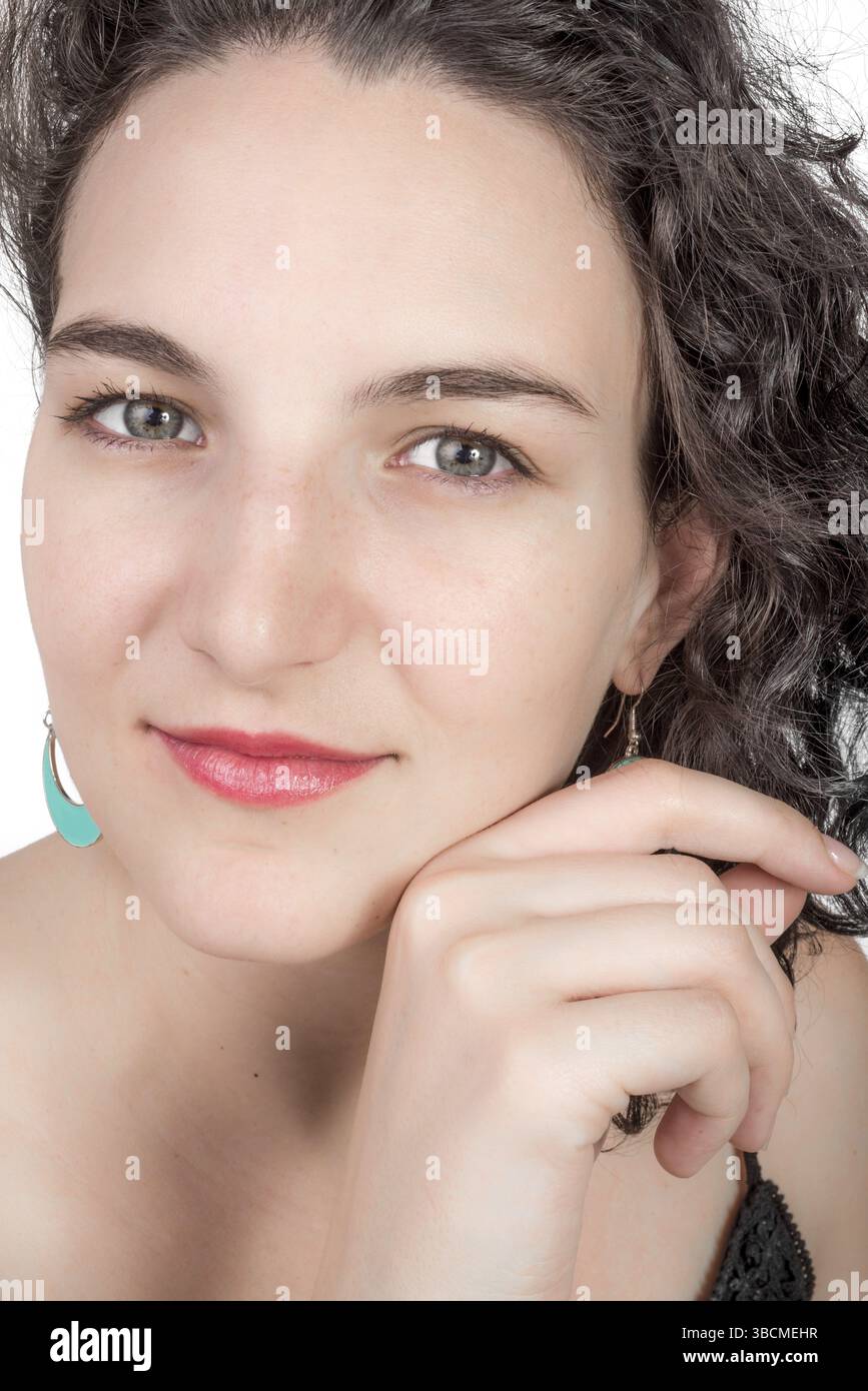 Junges weibliches Modell mit offenem Schulterkleid und aquafarbenen Ohrringen im mittelöstlichen Design Stockfoto