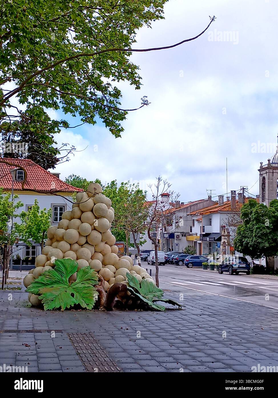 Azeitão Portugal 2. Mai 2025 künstlerische Installation in Form eines Traubenbusches mit großen Blättern auf dem öffentlichen Platz in Wohngegend Stockfoto