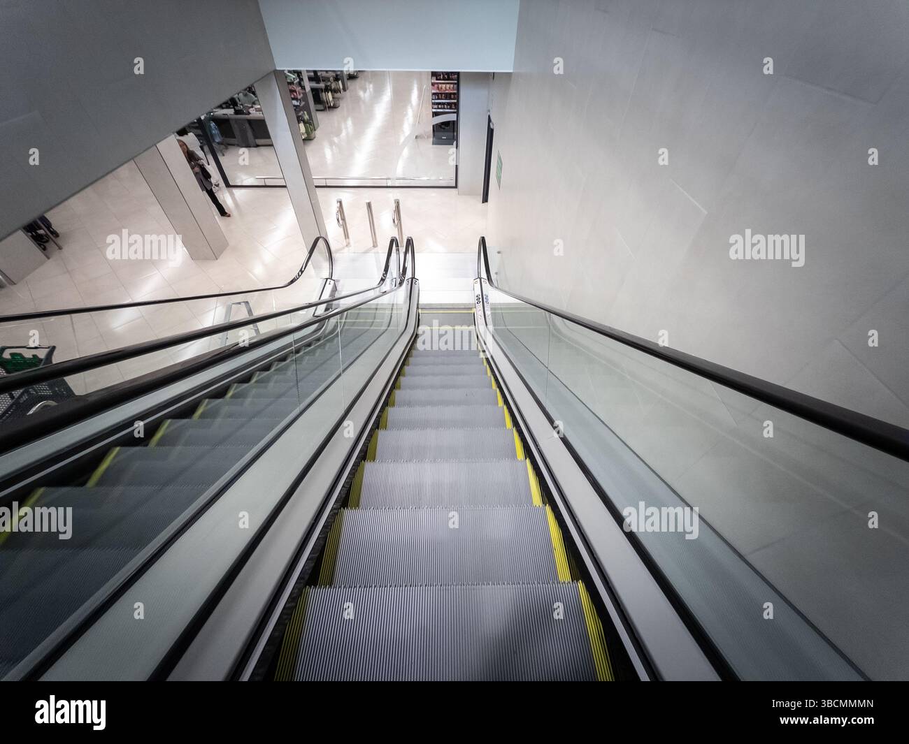 BARCELONA, SPANIEN - 12. APRIL 2025: Blick nach unten von der Oberseite einer Rolltreppe, während sie zum Lebensmittelboden eines Supermarktes in Barcelona, illu, hinabsteigt Stockfoto