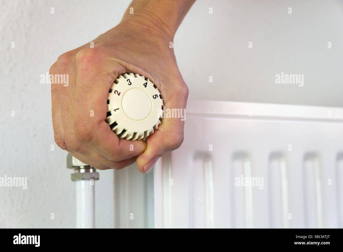 Hand drehen Heizungsregler öffnen im kalten Winter Stockfoto