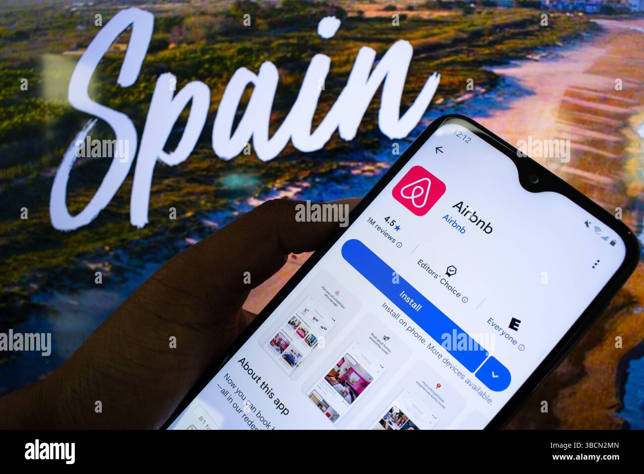 San Francisco, CA, 20. Mai 2025: Mann hält Smartphone mit Airbnb-App vor der spanischen Tourismusseite, da neue Mietgesetze auf Wohnungsknappheit abzielen. Stockfoto