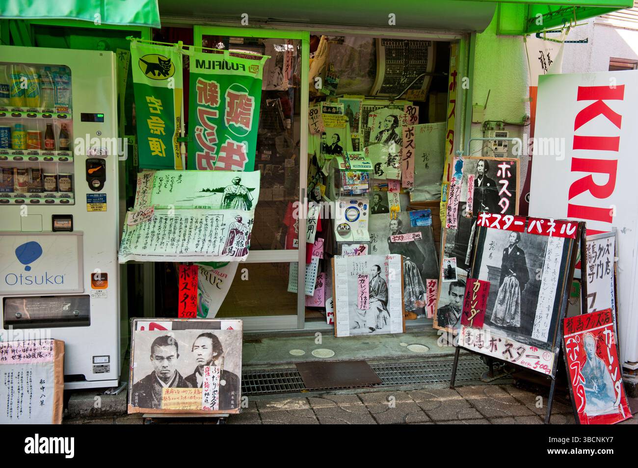 Hodgepodge Disarray Sammlung von Tosa Samurai Sakamoto Ryoma Fotos und Plakate, die über der Ladenfront eines Ladens in Kochi, Shikoku, Japan verputzt sind. Stockfoto