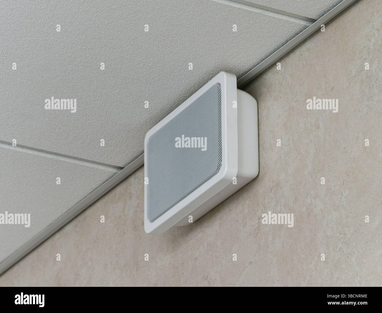 Lautsprecher für die Notfall- und Brandmeldeanlage, an der Wand unter der abgehängten Decke montiert. Stockfoto