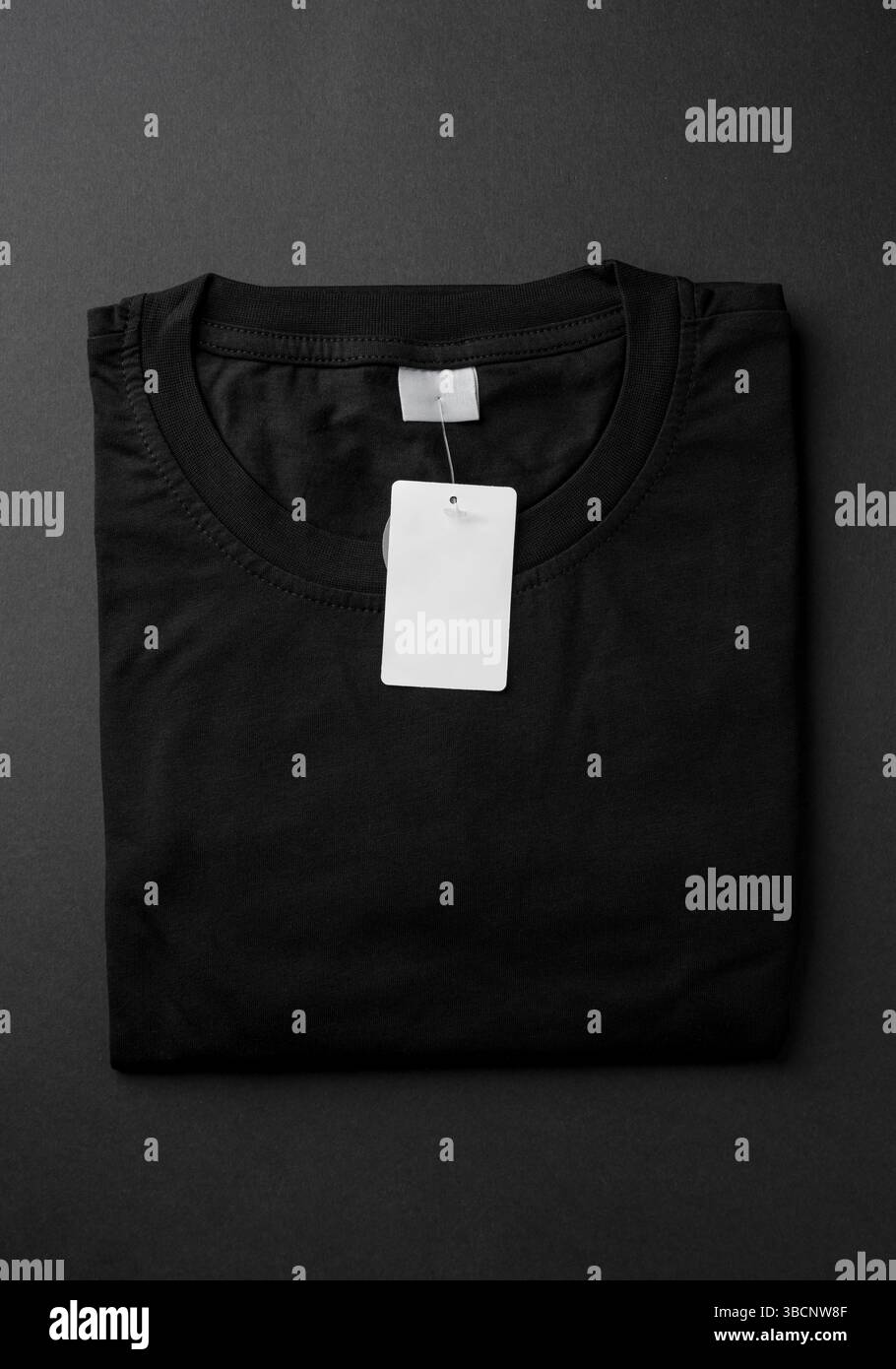 Nahaufnahme des schwarzen T-Shirt-Kragens mit leerem weißem Etikett Stockfoto