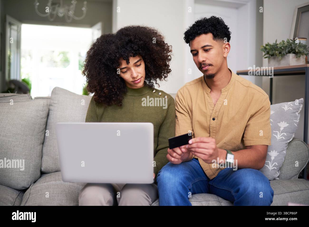 Paar Bewertungen Online-Shopping-Möglichkeiten gemeinsam in gemütlichem Zuhause Stockfoto