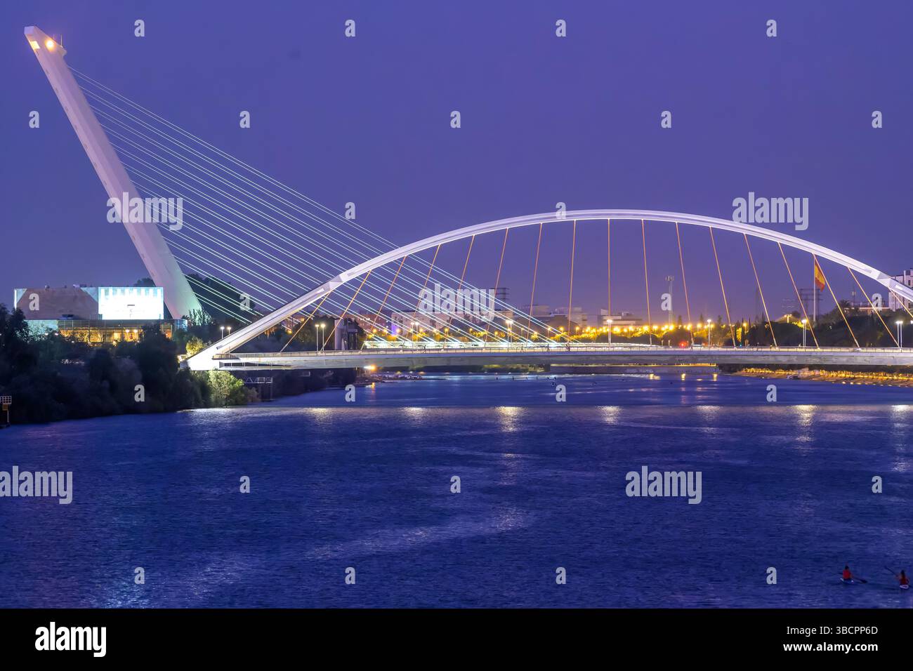 Die beleuchteten Brücken Barqueta und Alamillo unterstreichen die Skyline Sevillas und zeigen Eleganz und Gelassenheit in der Dämmerung. Stockfoto