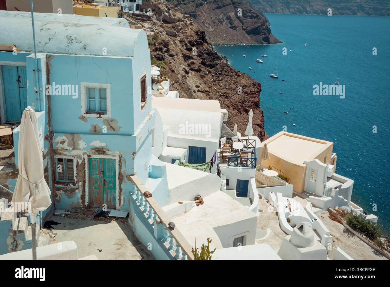 Zahlreiche weiße und blaue Häuser auf der Klippe. Oia Dorf Santorin Insel im Vordergrund, Ägäis Meer im Hintergrund. Stockfoto