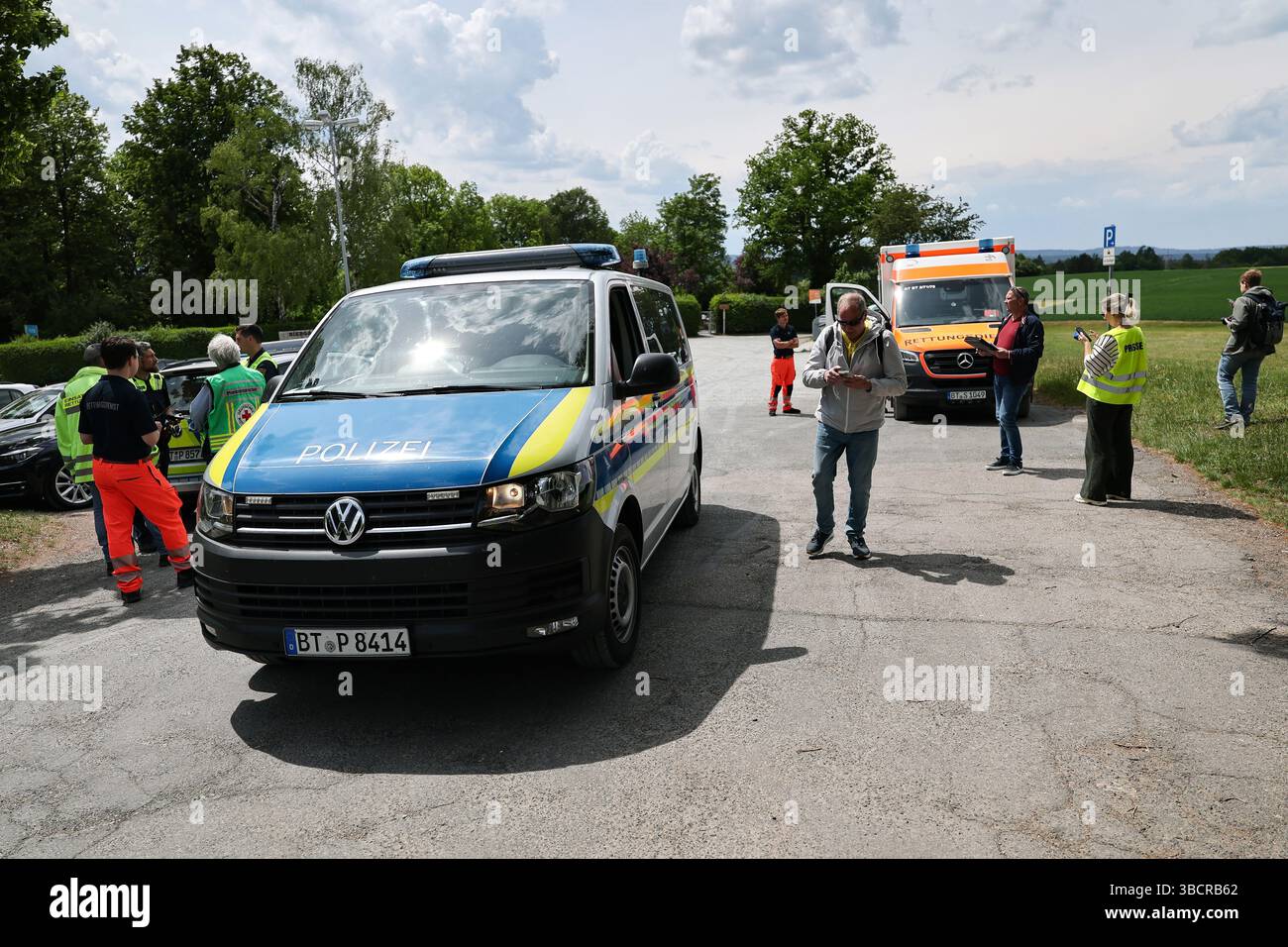 Bayreuth, Deutschland. Mai 2025. Polizei und Rettungsdienste stehen auf einem Parkplatz in der Nähe der Sekundarschule. Ein Schüler hatte eine amerikanische Handgranate aus dem Zweiten Weltkrieg gefunden, die von einem Abbruchteam sicher detoniert wurde. Darlegung: Daniel Löb/dpa/Alamy Live News Stockfoto