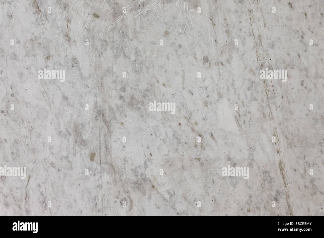 Nahaufnahme einer hellgrauen Marmoroberfläche mit Kratzern und natürlichen Adern, perfekt für Hintergründe, Architektur oder Design-Mockups Stockfoto