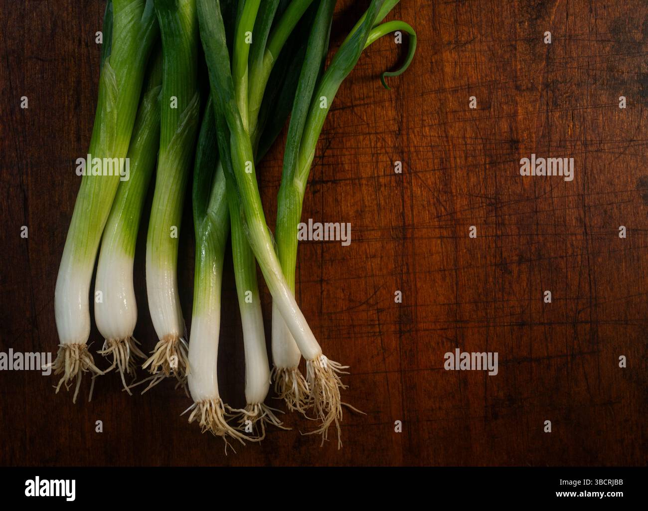 Schalotten gegen raues Schneidebrett Stockfoto