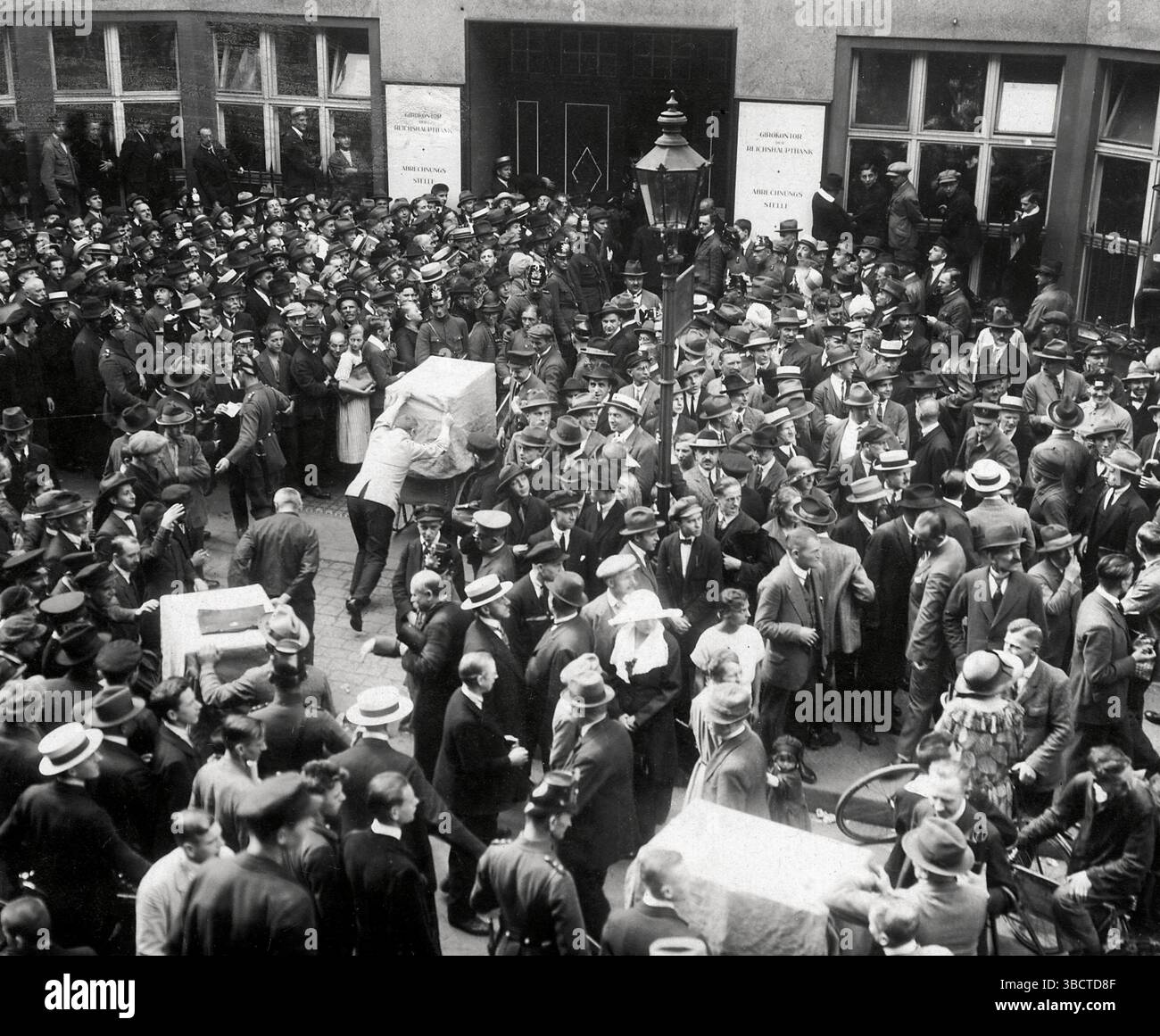 Wagen mit Notizen von 100.000 Mark oder mehr werden in das Bankgebäude gefahren. Berlin, 1923. Die deutsche Papiermark, die Währung der Weimarer Republik, wurde von 1921 bis 1923 von einer Hyperinflation betroffen, vor allem 1923. Der Kurswert der Mark fiel von 320 Mark pro Dollar Mitte 1922 auf 7.400 Mark pro US-Dollar im Dezember 1922. Diese Hyperinflation setzte sich bis ins Jahr 1923 fort, und im November 1923 war ein US-Dollar 4.210.500.000.000 Mark Wert. Stockfoto Wagen mit Notizen von 100.000 Mark oder mehr werden in das Bankgebäude gefahren. Berlin, 1923. Die deutsche Papiermark, die Währung der Weimarer Republik, wurde von 1921 bis 1923 von einer Hyperinflation betroffen, vor allem 1923. Der Kurswert der Mark fiel von 320 Mark pro Dollar Mitte 1922 auf 7.400 Mark pro US-Dollar im Dezember 1922. Diese Hyperinflation setzte sich bis ins Jahr 1923 fort, und im November 1923 war ein US-Dollar 4.210.500.000.000 Mark Wert. Stockfoto