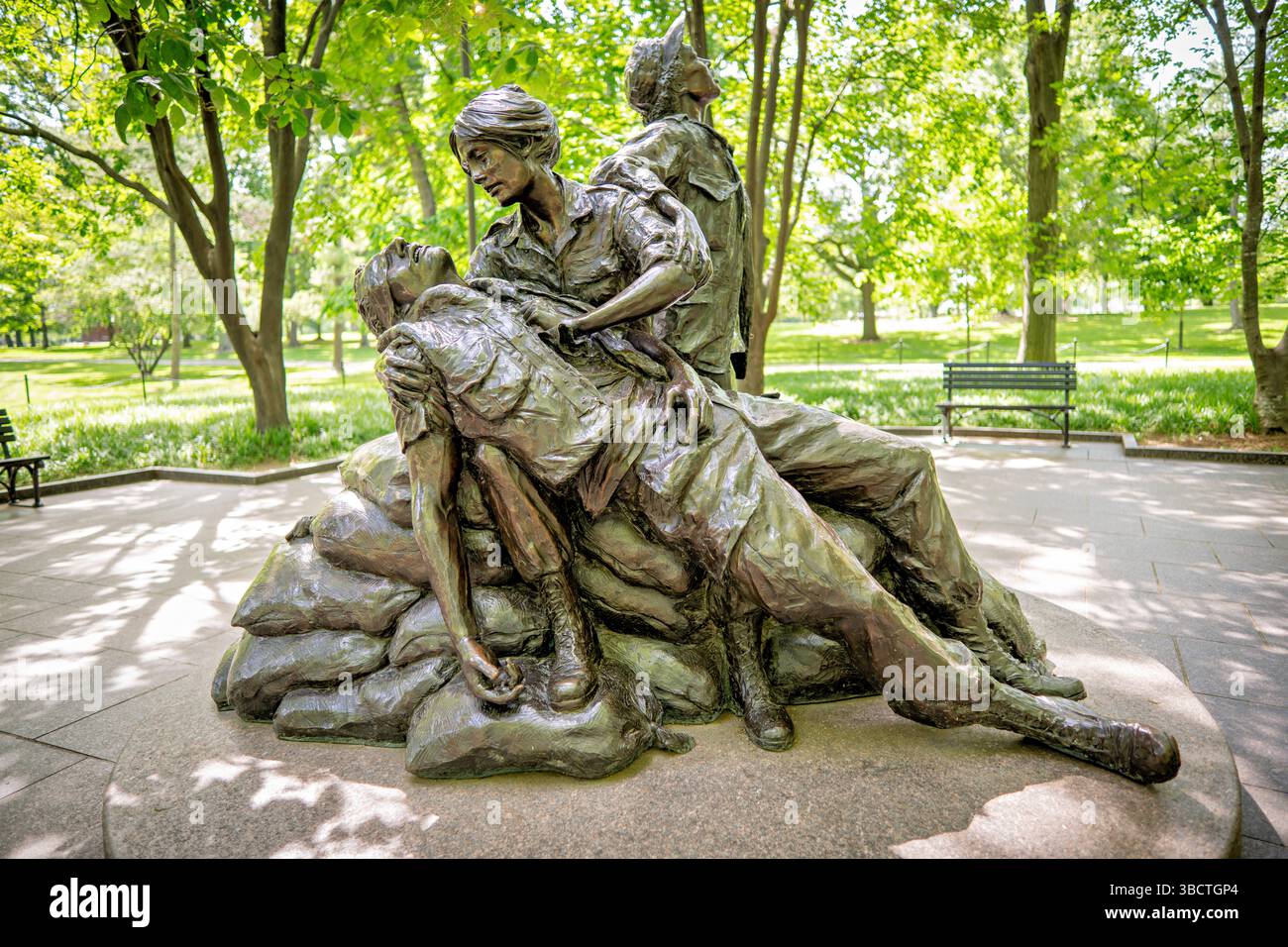 WASHINGTON DC – das Vietnam Women's Memorial befindet sich in der Nähe des Vietnam Veterans Memorial in der National Mall. Diese Bronzeskulptur wurde von der Bildhauerin Glenna Goodacre entworfen und am Veterans Day, dem 11. November 1993, gewidmet und ehrt die über 265.000 Frauen aus Militär und Zivilisation, die während des Vietnamkriegs dienten. Die Gedenkstätte zeigt drei uniformierte Frauen, die sich um einen verwundeten Soldaten kümmern, und symbolisiert die wichtige Rolle, die Frauen während des Konflikts gespielt haben, insbesondere als Krankenschwestern und medizinisches Hilfspersonal. Stockfoto