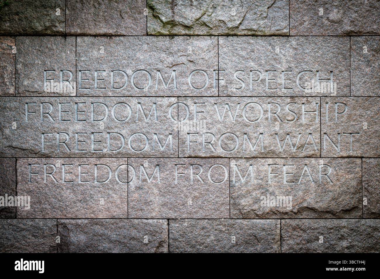 WASHINGTON DC – die vier Freiheiten, die Präsident Franklin D. Roosevelt 1941 in seiner Rede zur Lage der Union formulierte, sind in die Steinmauer des FDR Memorial in Washington DC eingeätzt. Das Denkmal befindet sich entlang des Tidal Basin im West Potomac Park und zeigt die Inschriften „REDEFREIHEIT“, „FREIHEIT DER ANBETUNG“, „FREIHEIT VON NOT“ und „FREIHEIT VON ANGST“, die in Granit eingemeißelt sind. Diese vier Prinzipien bildeten einen Eckpfeiler von Roosevelts Vision für eine Nachkriegswelt und wurden später in die Charta der Vereinten Nationen aufgenommen. Das 1997 eingeweihte FDR-Denkmal erstreckt sich über 7,5 ac Stockfoto