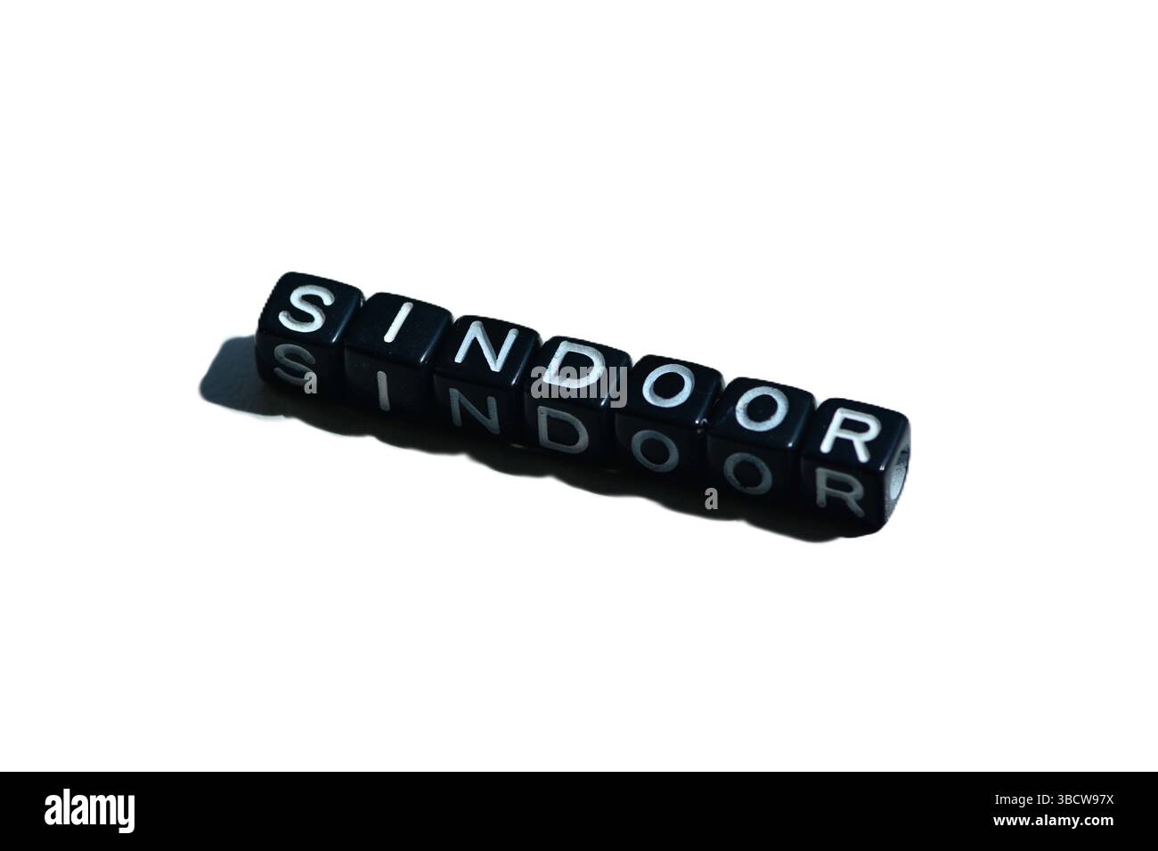 Sindoor mit schwarzen Perlen auf isoliertem Hintergrund geschrieben. Kulturelles Symbol der hinduistischen Ehe; evoziert auch Identität, Geschlechterdebatten und Indien-Pakistan Stockfoto