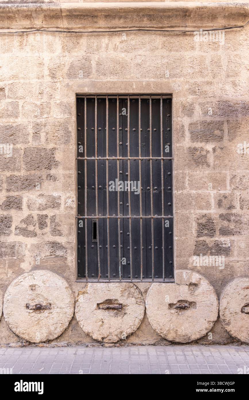 Casco Antiguo, Sevilla, Andalusien, Spanien. Steinräder wurden im Fundament eines alten spanischen Gebäudes verwendet. Stockfoto