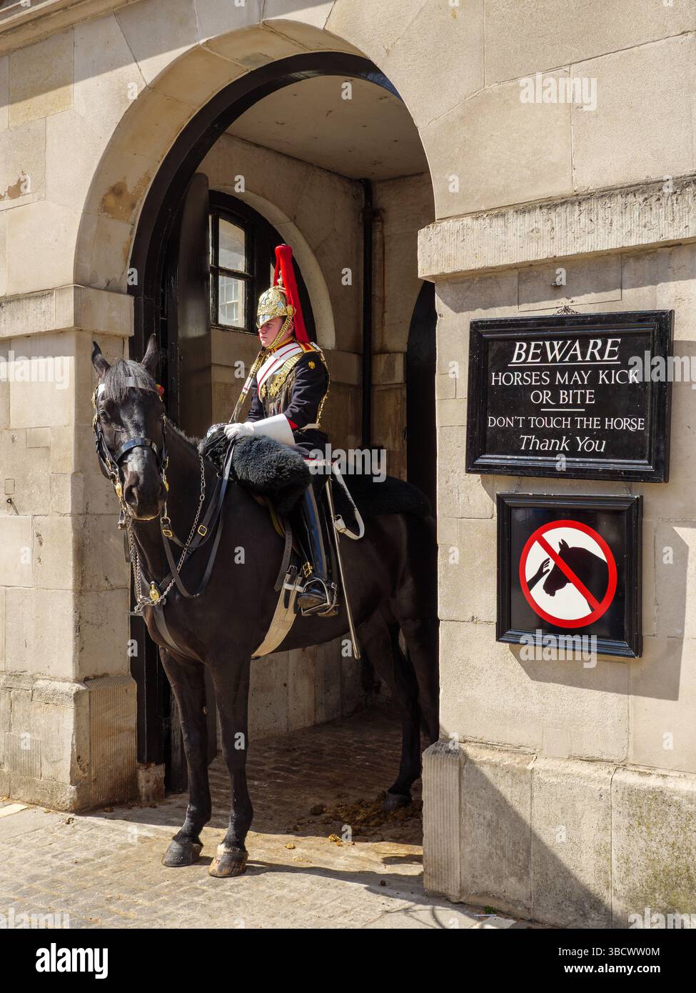 Die Household Cavalry Life Guards neben dem Warnschild, dass das Pferd beißen kann, Whitehall, London, Großbritannien Stockfoto