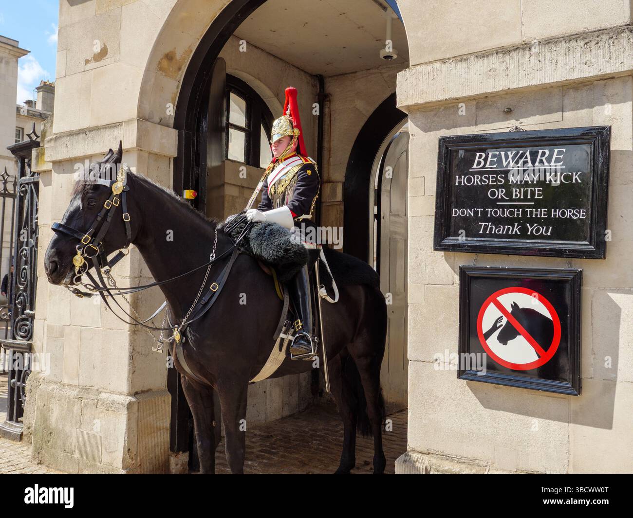 Die Household Cavalry Life Guards neben dem Warnschild, dass das Pferd beißen kann, Whitehall, London, Großbritannien Stockfoto