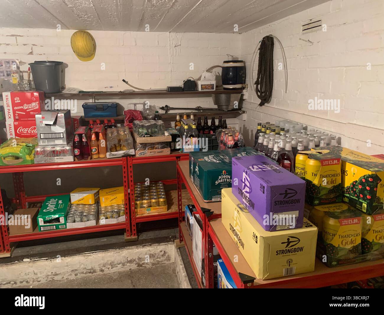 Getränk Bier Keller Schnaps Flasche Flaschen Keller gehalten Kaltstapel gestapelt hohe Menge Wein Pakete Packet Box Boxen Hut Helm gelb Schutzhelm - Smartphone-aufgenommenes Stockfoto