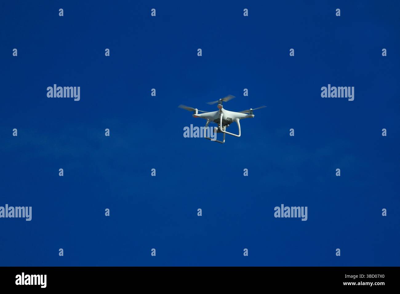 Drohne mit kleiner Action-Kamera fliegt ein Bild in blauem Himmel Stockfoto