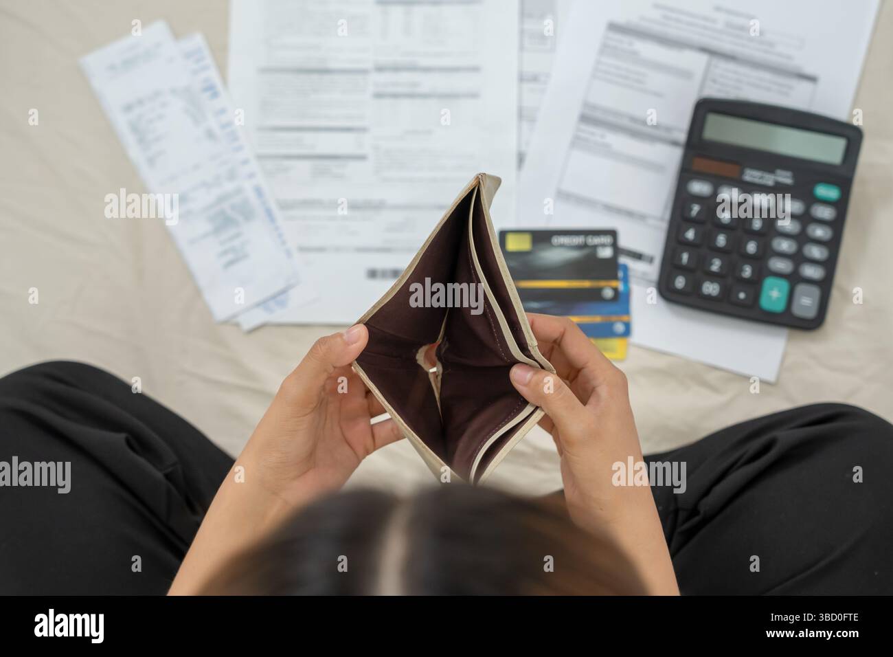 Gestresste und Kopfschmerzen Frau mit großen Rechnungen oder Rechnungen, kein Geld für Ausgaben und Kreditkartenschulden. Knappheit, Finanzproblem, Konkurs, Mo Stockfoto