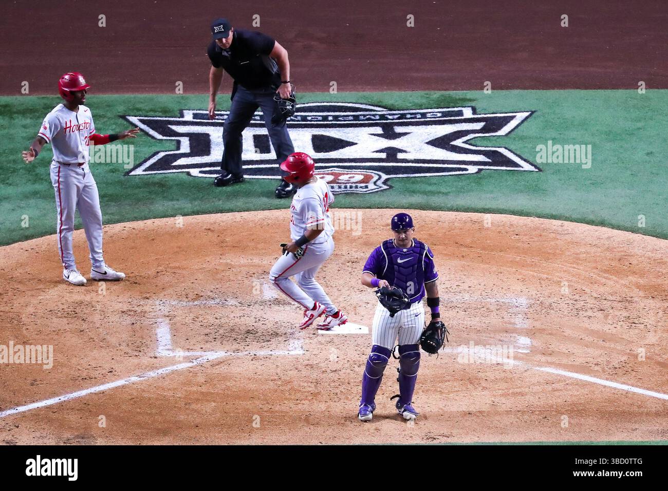 Arlington, Texas, USA. Mai 2025. Der Kansas State Catcher BÄR MADLIAK (3) wartet auf einen Heimwurf, als KENNETH JIMENEZ (31) aus Houston den Teller überquert, während die Heimplattenteam 2025 am Mittwoch bei der Phillips 66 Big 12 Baseball Championship auf dem Globe Life Field in Arlington das Spiel der ersten Runde von Houston gegen Kansas State aufmerksam beobachtet. (Kreditbild: © Brian McLean/ZUMA Press Wire) NUR REDAKTIONELLE VERWENDUNG! Nicht für kommerzielle ZWECKE! Stockfoto