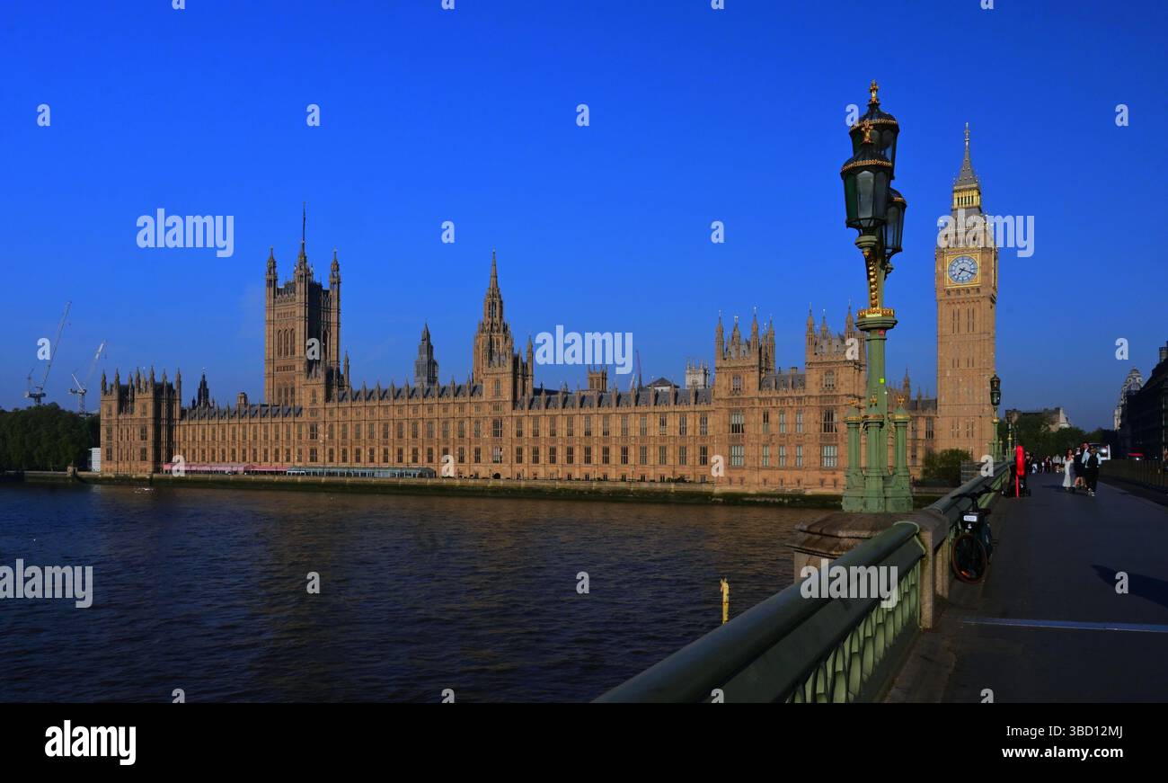 Houses of Parliament und Big Ben am frühen Morgen auf der Westminster Bridge mit blauem Himmel, wenige Menschen ohne Verkehr Stockfoto