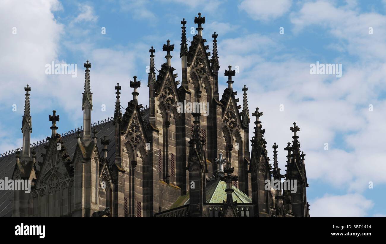 Gotische Kathedraltürme gegen einen hellen, bewölkten Himmel Stockfoto