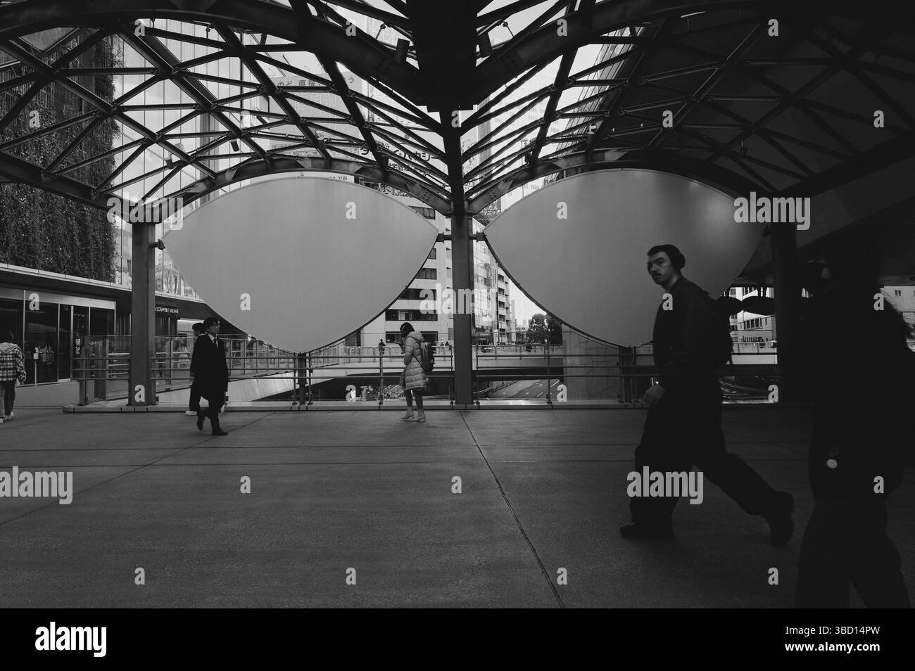 Einfarbiges morgendliches Treiben unter dem eindrucksvollen Baldachin des Shibuya Streams Stockfoto