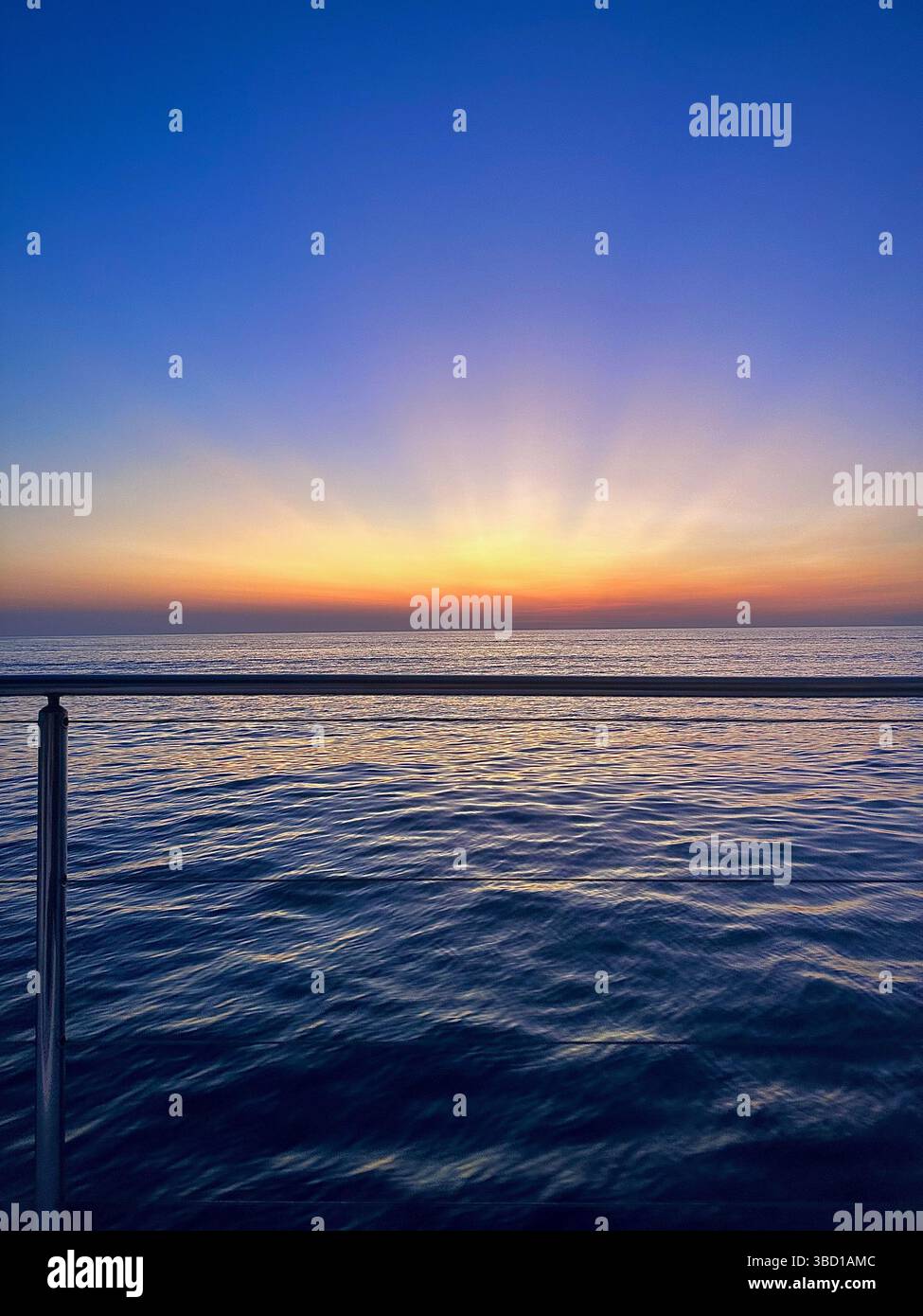 Sonnenuntergänge über dem ruhigen Meereswasser, von einem Boot aus betrachtet – eine ruhige Meereslandschaft, die ideal für Reisen, Luxus, Wellness und inspirierende Themen ist. - Smartphone-aufgenommenes Stockfoto