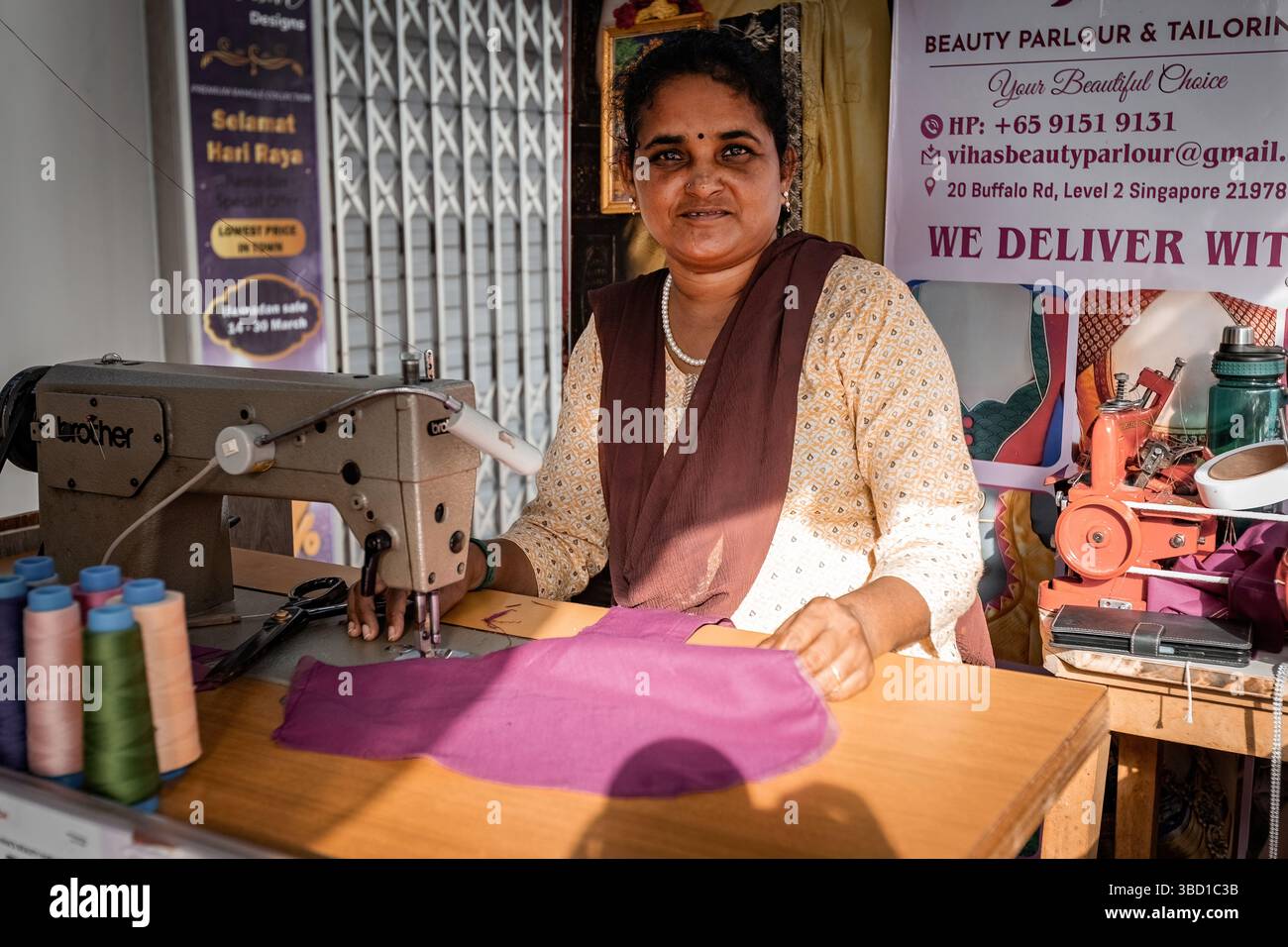 Indische Frau, die in der Schneiderei in Little India in Singapur arbeitet Stockfoto