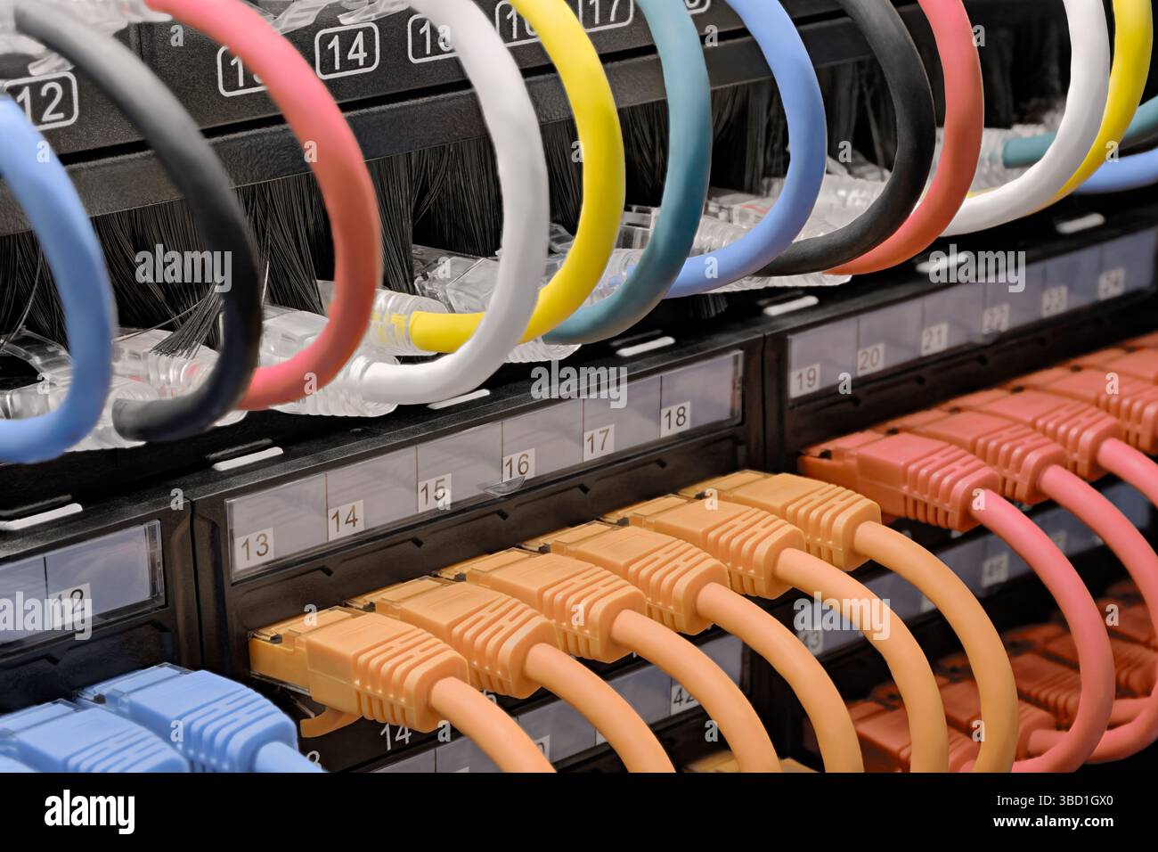 Rechenzentrum, Netzwerkpanel, Switch und angeschlossene mehrfarbige Kabel. Nahaufnahme, selektiver Fokus, Hintergrund zu Netzwerktechnologien. Stockfoto