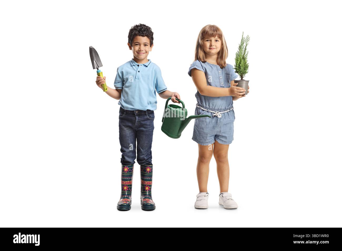 Ein asiatischer Junge, der eine Gießkanne hält, und ein weißes Mädchen, das einen kleinen Baum in einem Topf auf weißem Hintergrund hält Stockfoto