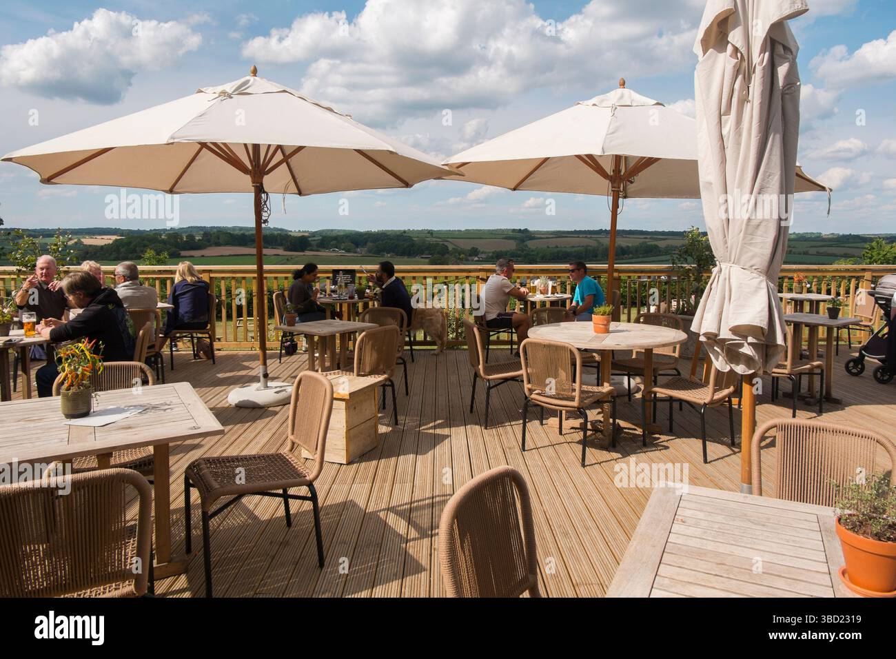 Die Terrasse mit Blick auf das Windrush Valley in Jeremy Clarkson's Pub, The Farmer's Dog, in den Cotswolds, Großbritannien. Stockfoto
